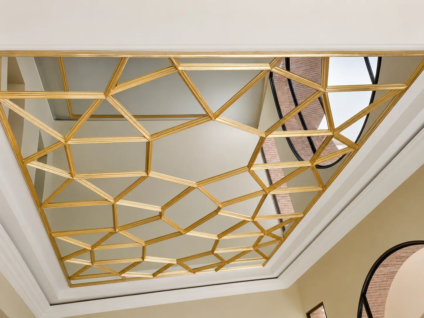 Miroir de plafond à motifs géométriques dorés.