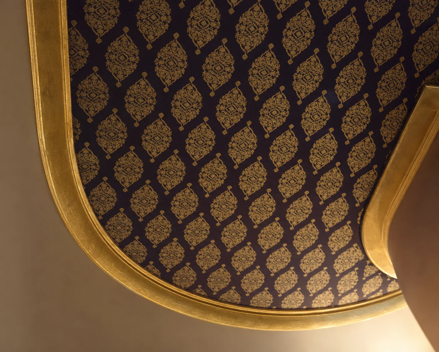 Plafond ovale noir orné de motifs dorés.
