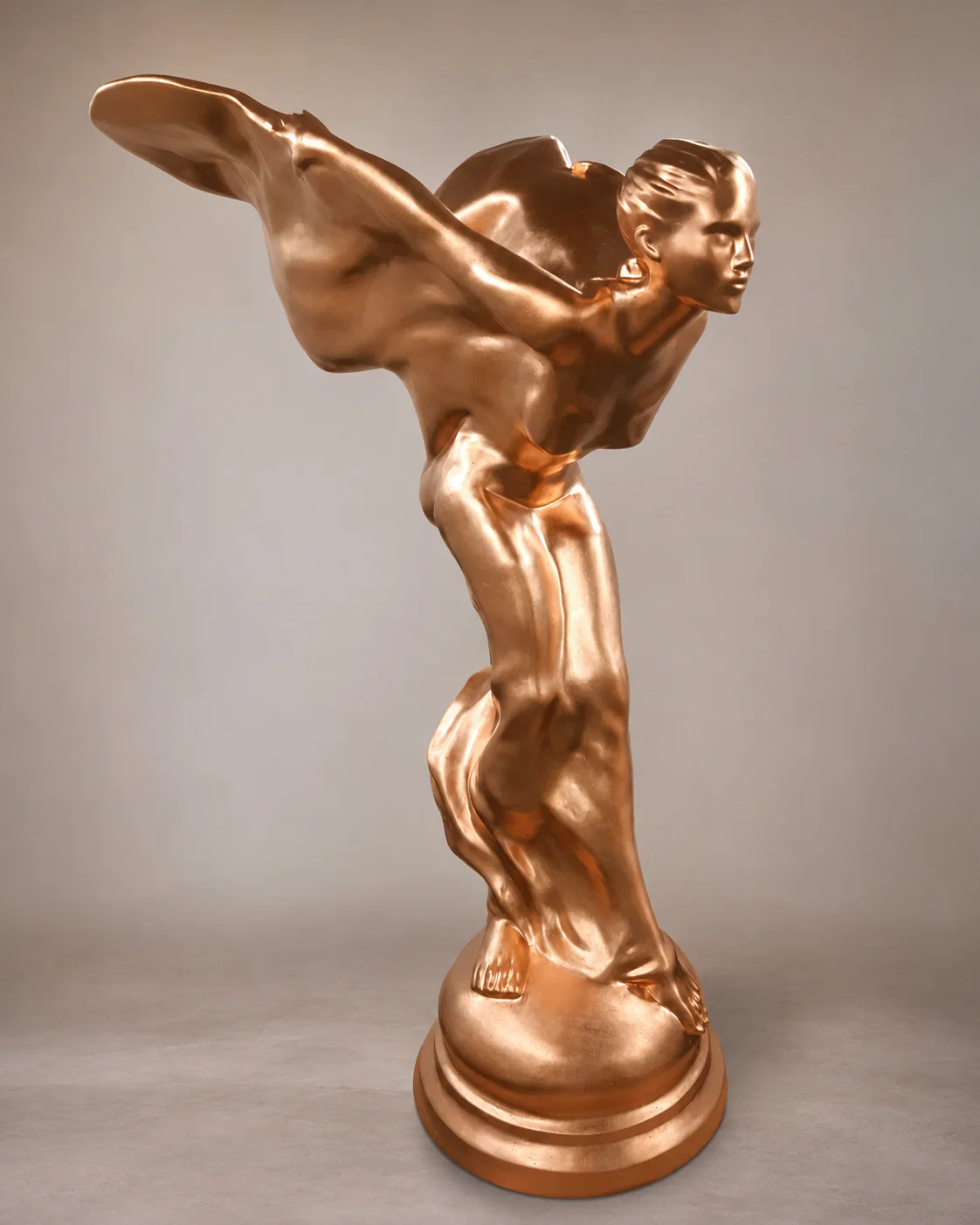 Sculpture féminine dorée en mouvement.