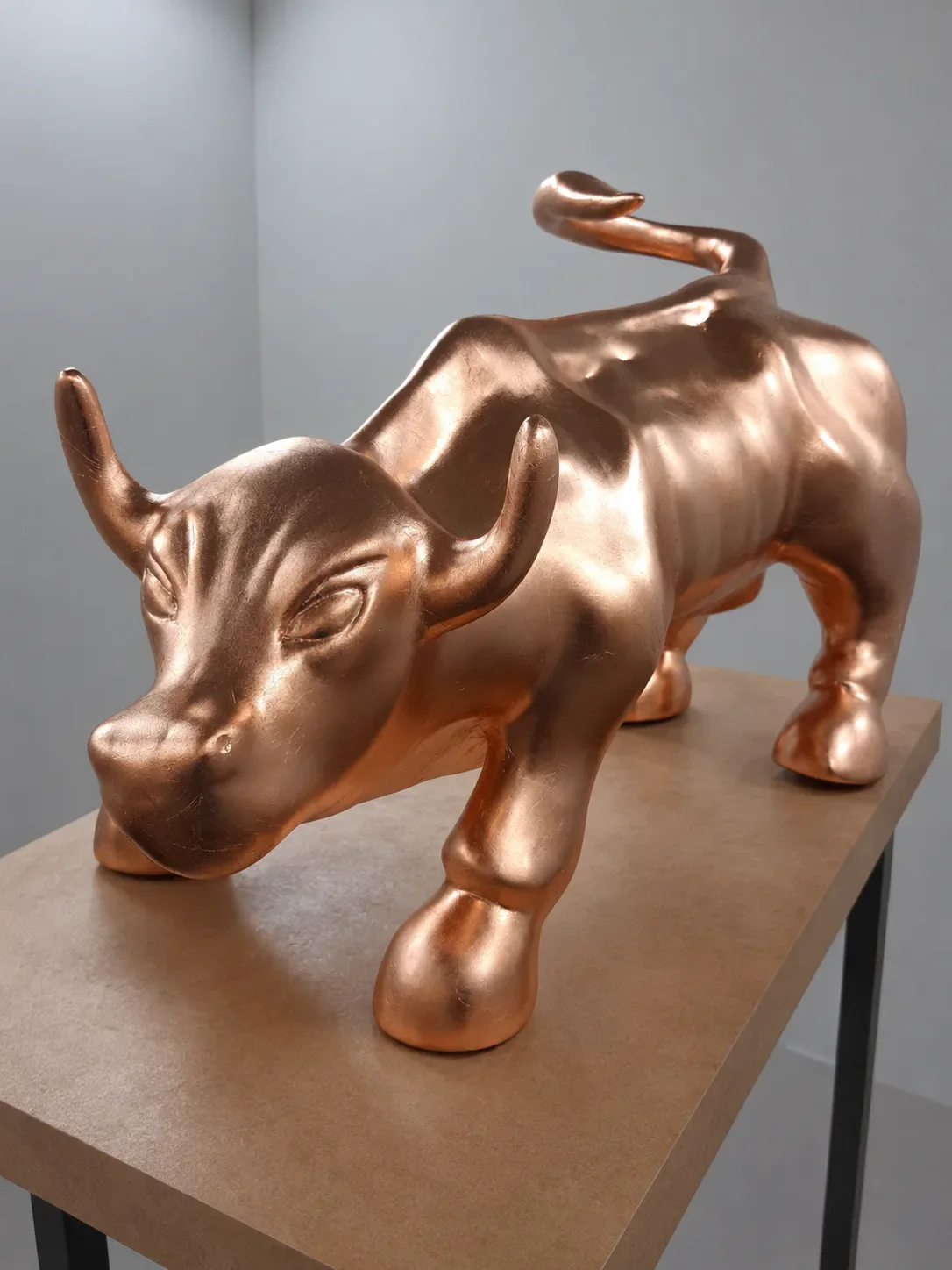 Sculpture de taureau dorée photographiée en studio.